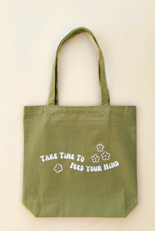 Groovy green canvas tote bag says take time to feed your mind with flowers